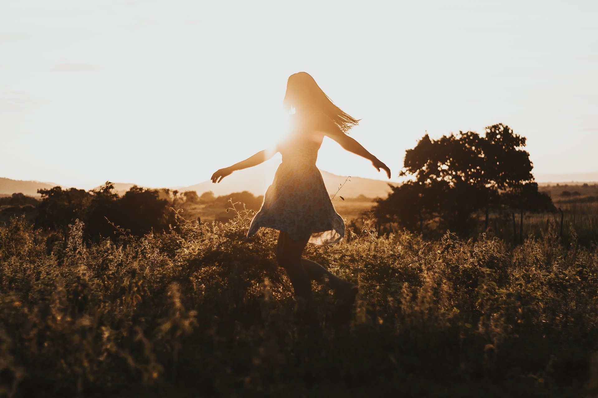 Image of woman celebrating new found hope by enjoying sunshine in a meadow