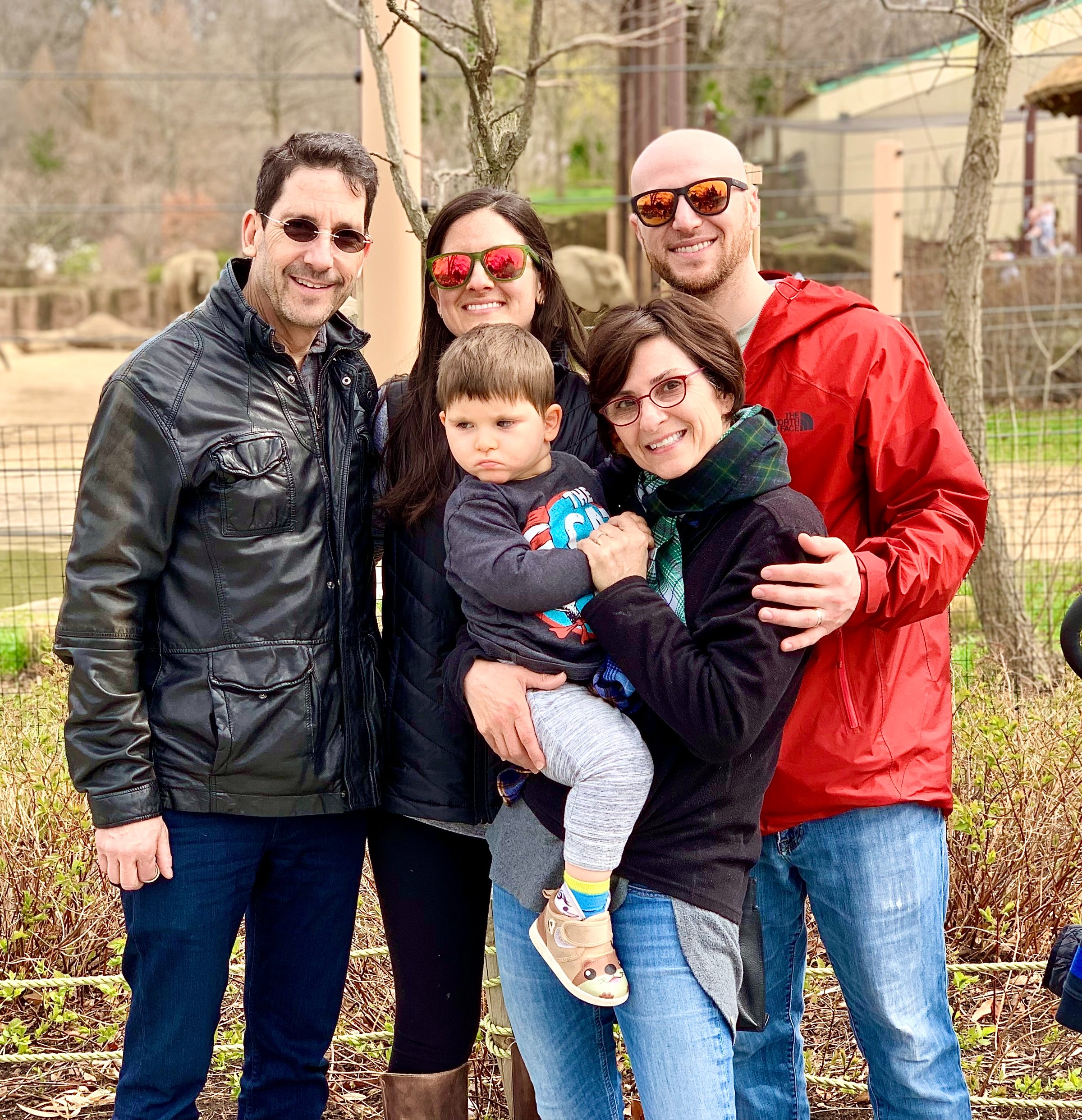 Photo of Cooper New (centre) being held by his grandmother Liz Cooper, together with his parents Sophie and Jordan New and grandfather Rusty Cooper