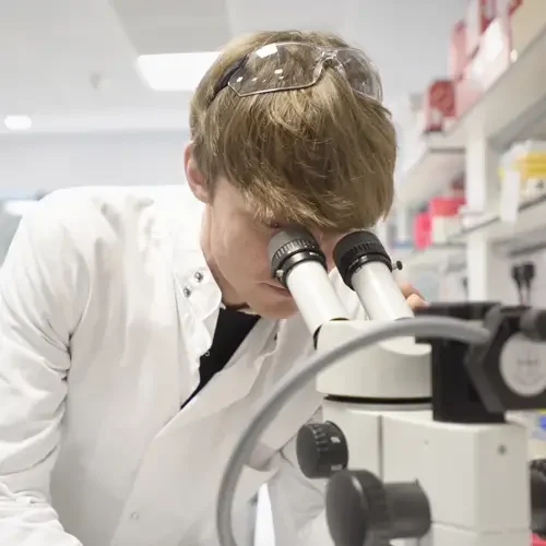 Scientist looking into telescope
