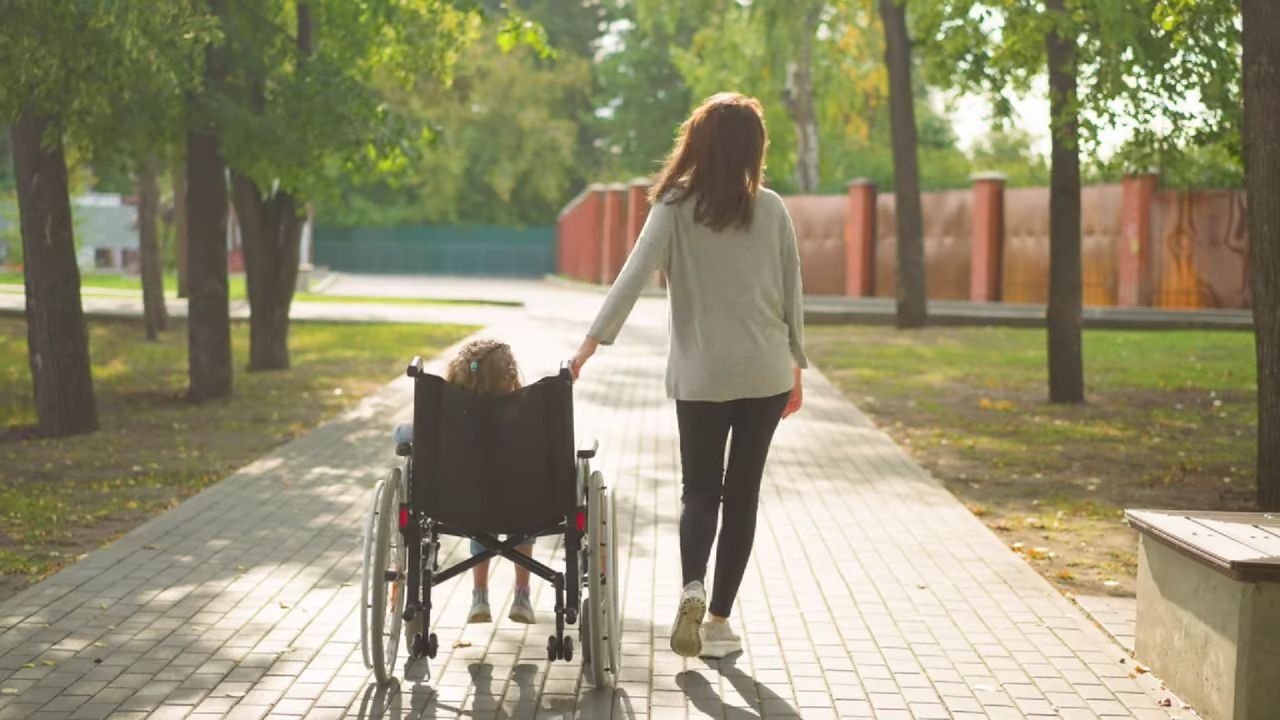 A child in a wheelchair and a parent or carer